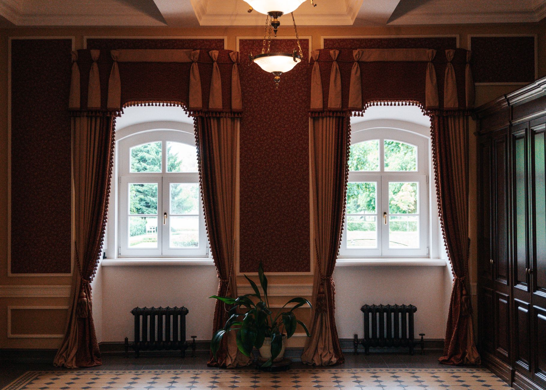 A luxurious interior showcasing vintage window drapes, elegant lighting, and classic decor elements